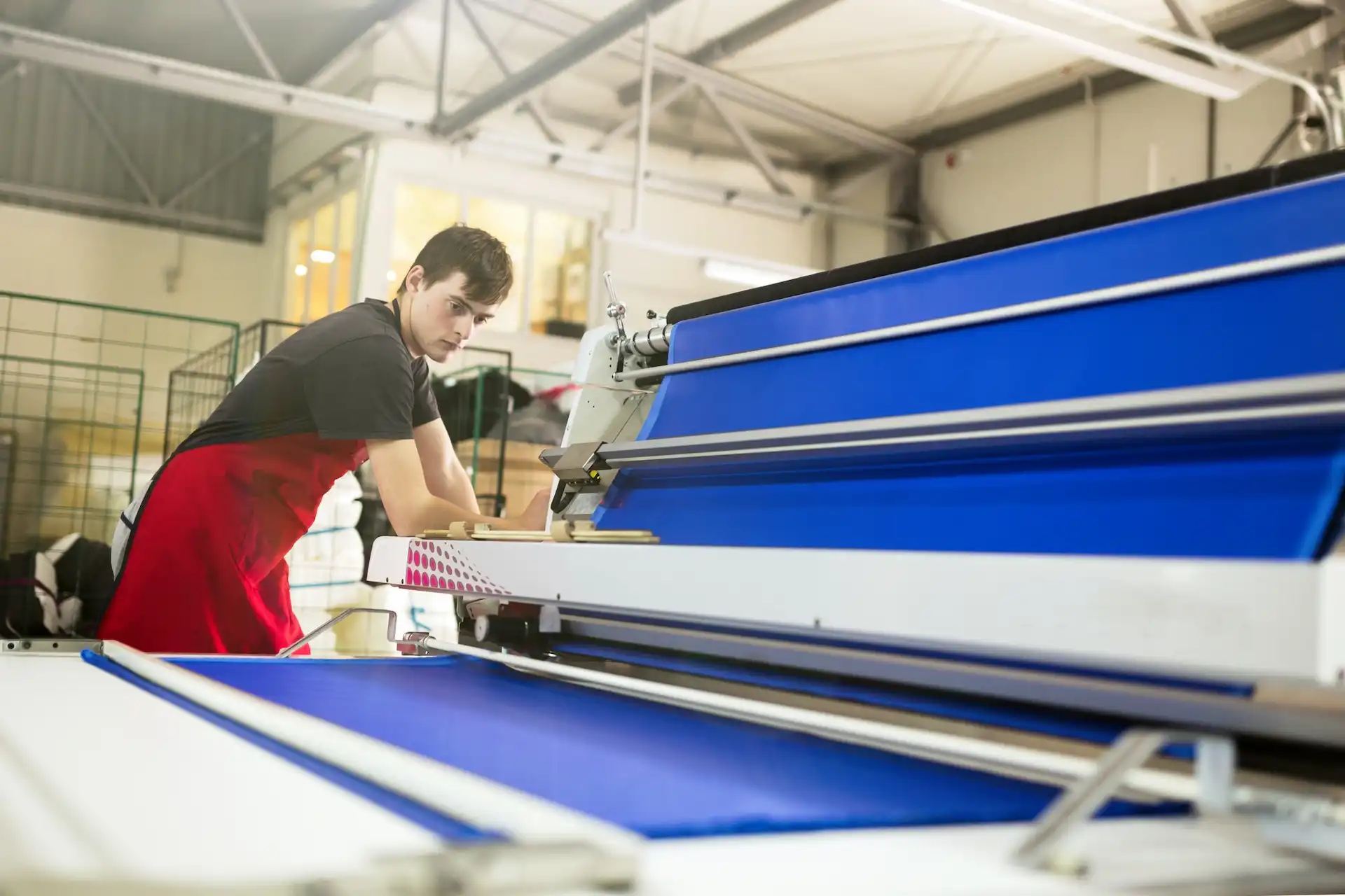 Worker handling rolls of fabric
